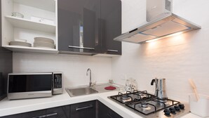 A modern kitchen with a microwave, sink, stove, and cabinets.