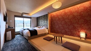 Une chambre d’hôtel avec un lit, une petite table et un canapé. Il y a une fenêtre donnant sur l’extérieur.