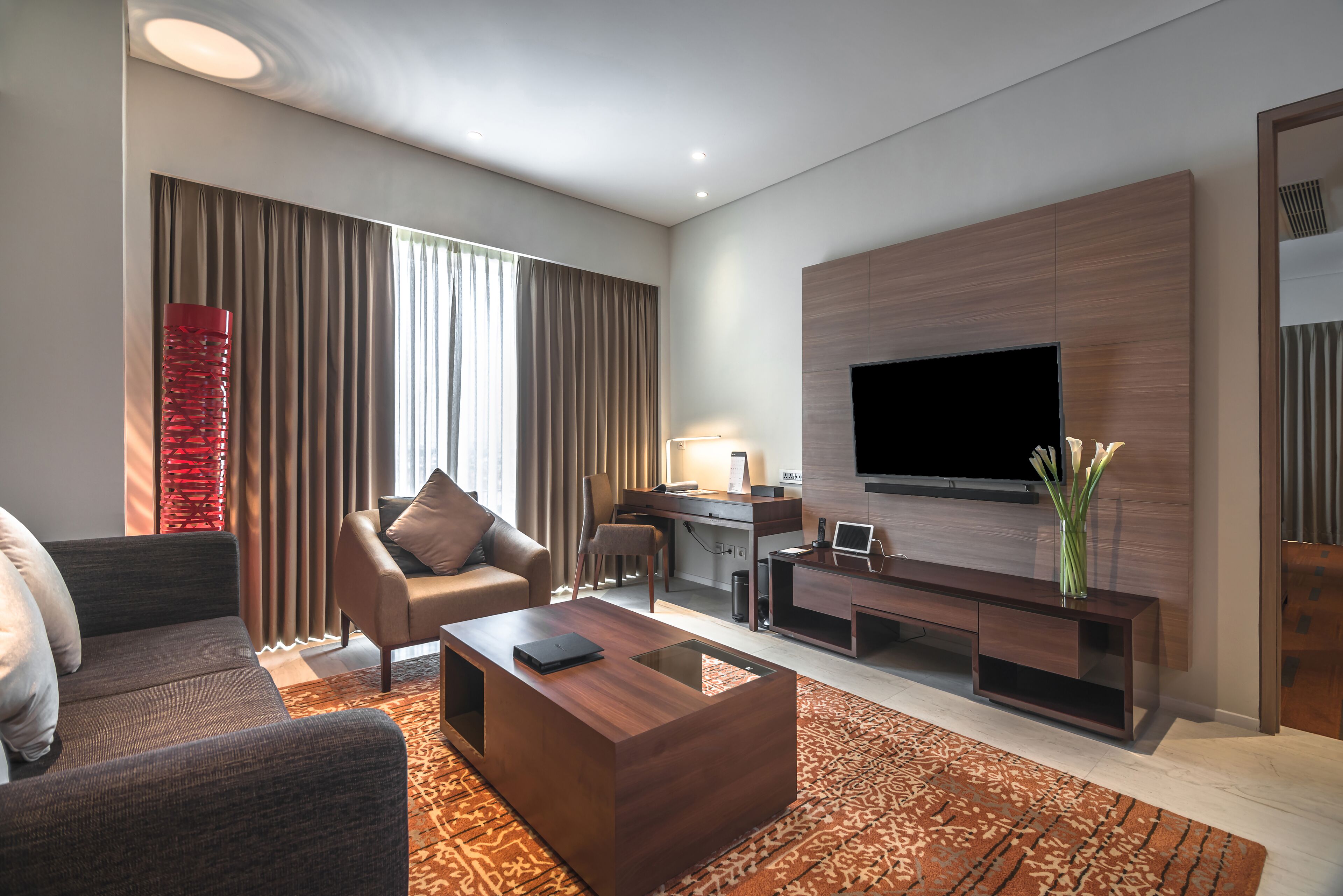 Una sala de estar moderna con sofá, mesa de centro y televisor.