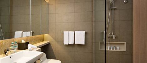 Une salle de bain moderne équipée d’une douche, de toilettes, d’un lavabo et d’un grand miroir.