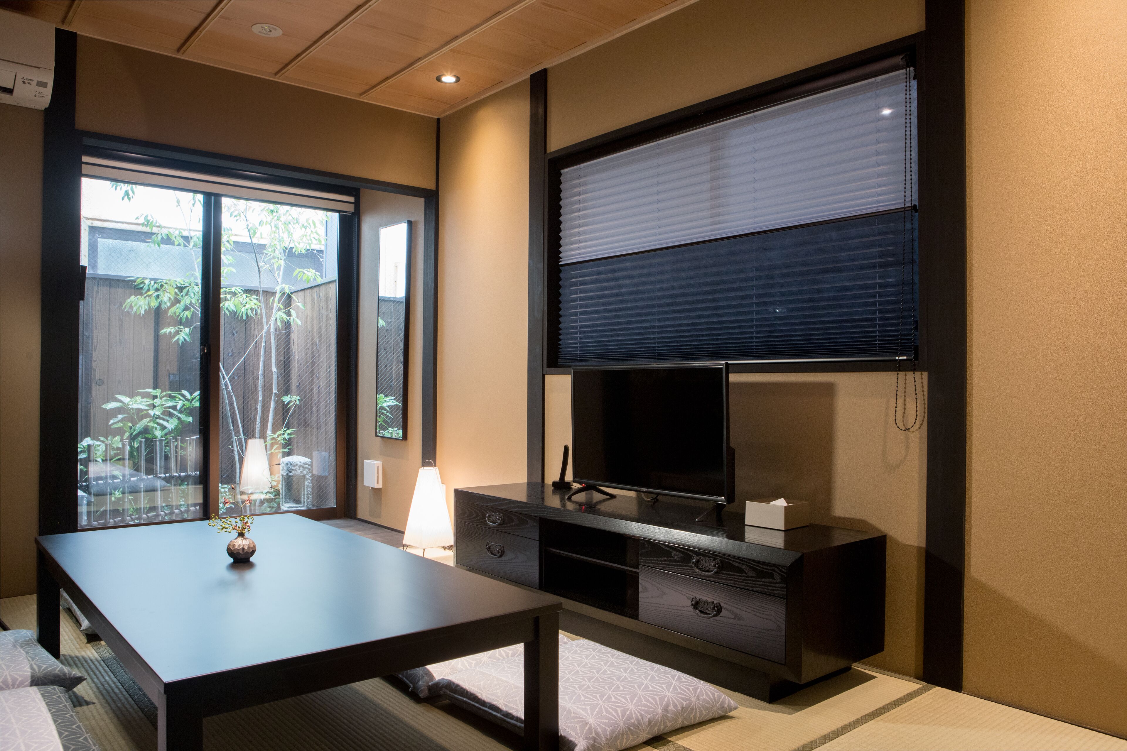 Un salon moderne avec un téléviseur, un canapé et une table à manger.