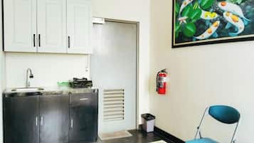 A kitchenette with a sink, cabinets, and a fire extinguisher.