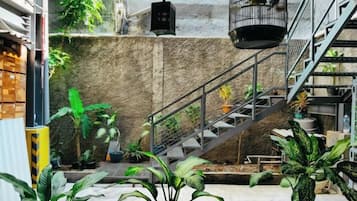 A staircase with metal railings, surrounded by potted plants, leading to a higher level.