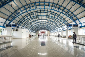 A spacious, well-lit train station with a high, arched ceiling and clear directional signage. - Portal Residence (Jakarta)