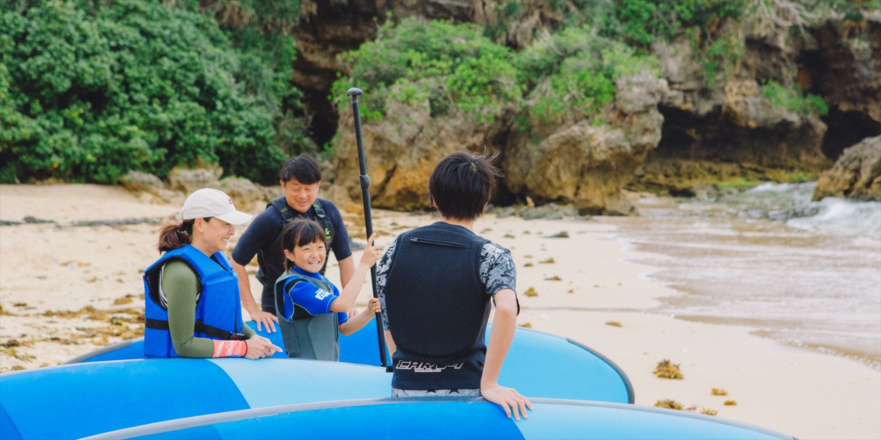 A group of people on a beach with inflatable rafts.