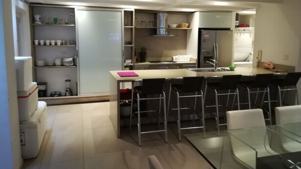 A modern kitchen with a central island, bar stools, and a dining table. - Apartment Santo Domingo, walled center  (Cartagena)
