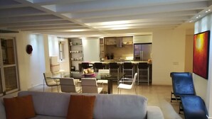 A modern living room with a sofa, chairs, a dining table, and a kitchen area in the background. - Apartment Santo Domingo, walled center  (Cartagena)