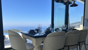 A dining table set for four with a view of the ocean.