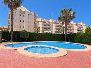 Une piscine dont le bord est orné du chiffre « 050 », entourée d’une terrasse recouverte de carreaux rouges.