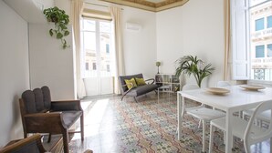 A spacious living area with a dining table, multiple chairs, a sofa, and a patterned floor. - Large bright apartment in Liberty building - Excellent position (Palermo)
