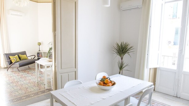 A dining area with a white table and chairs, a patterned floor, and a view through an open door. - Large bright apartment in Liberty building - Excellent position (Palermo)
