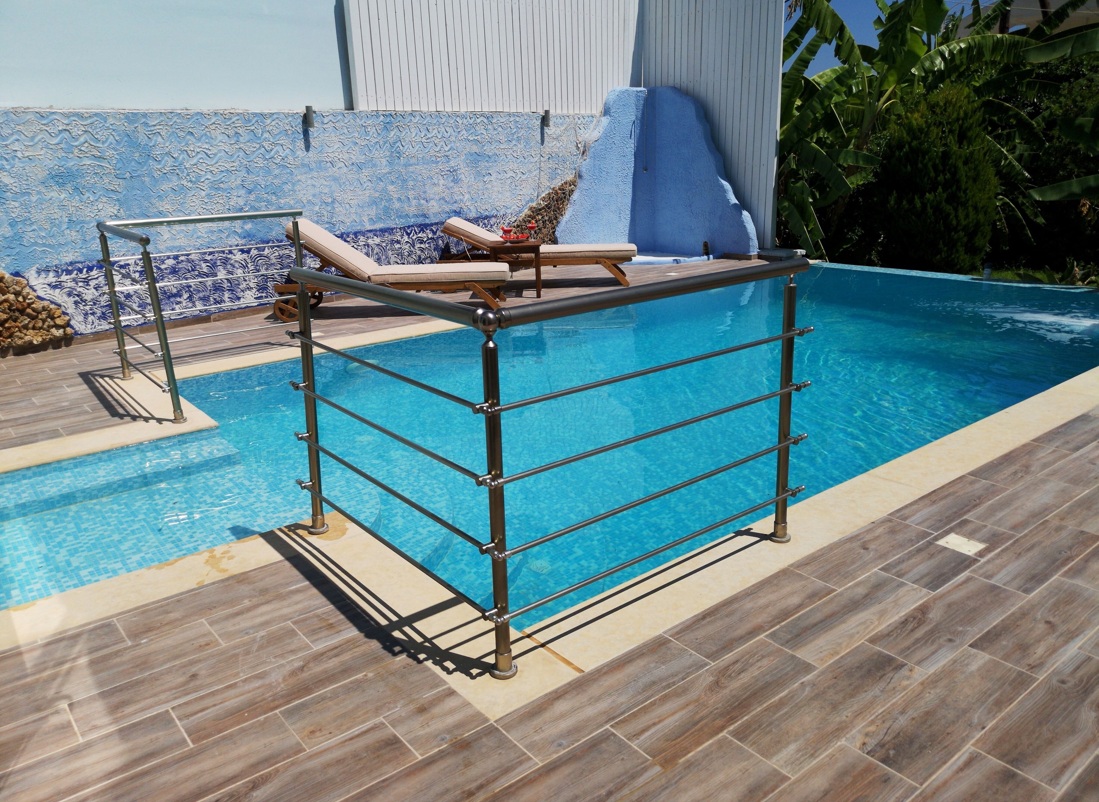 Ein Pool mit Metall-Sicherheitsgitter und Liegestühlen.