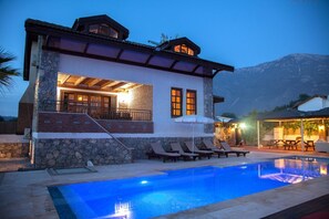 A two-story house with a swimming pool, stone exterior, and a mountain backdrop. - Heated Pool - Private villa. (Fethiye)