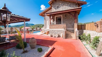 Guests can enjoy a balcony with a view of the surrounding landscape and relax in a patio area with outdoor seating.