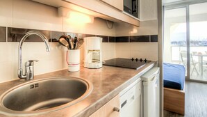 A modern kitchen with a stainless steel sink, a coffee maker, and a stove.
