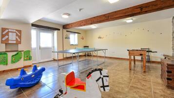 Enjoy meals and meetings at the central dining table, surrounded by whimsical decals and a wooden chest of drawers.