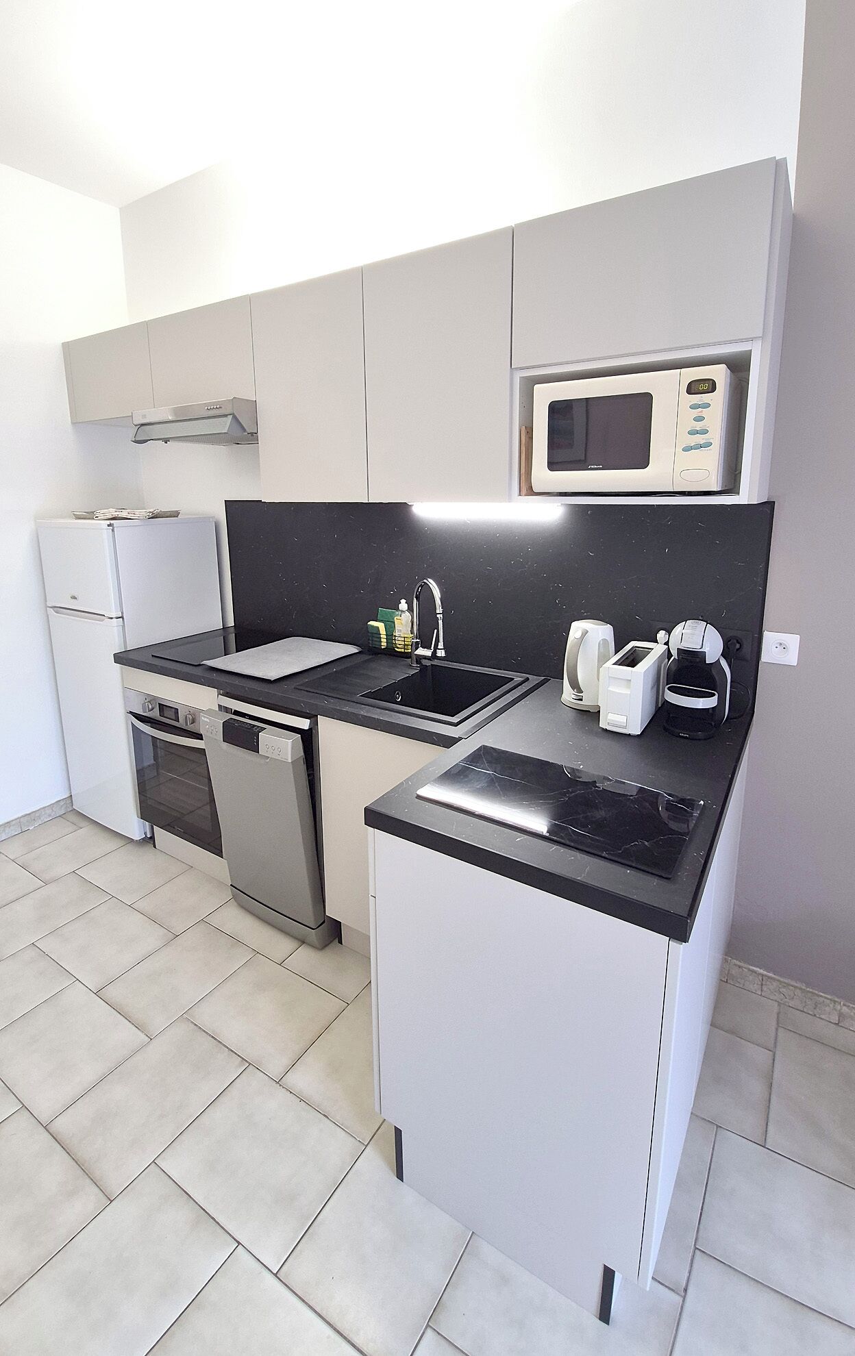 A compact kitchen with a microwave, toaster, and coffee maker.