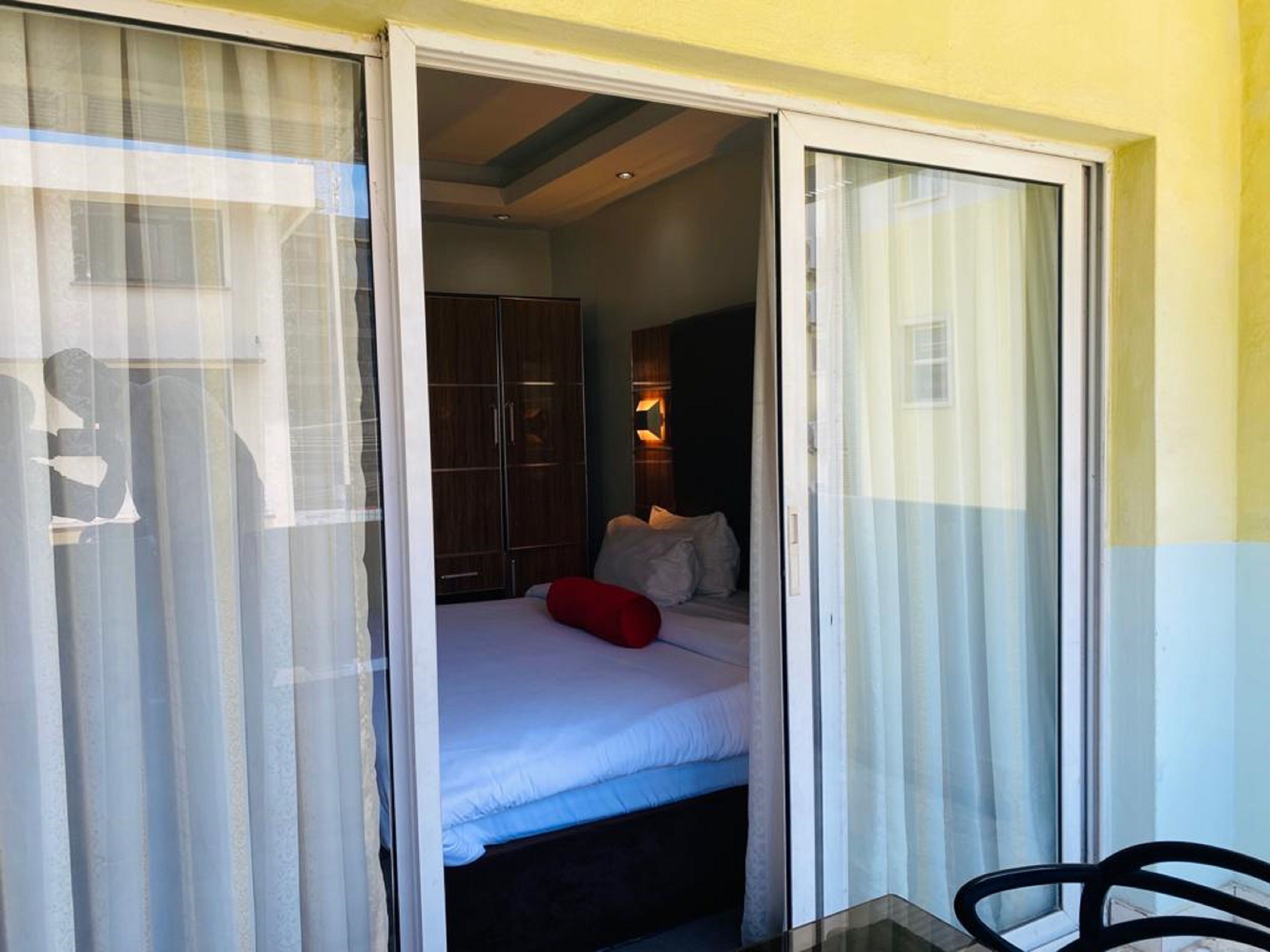 A bedroom with a bed, a wardrobe, and a nightstand.