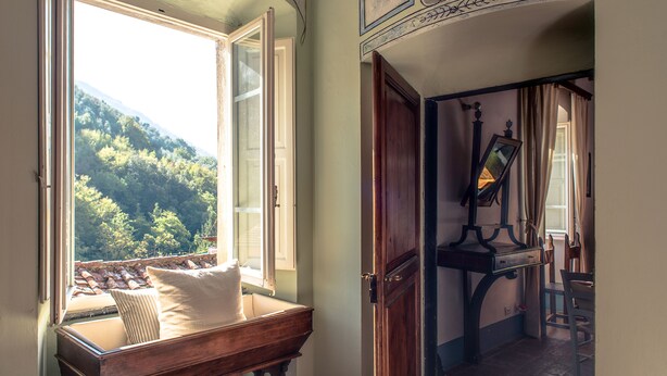 A room with a view of a forested mountain through a large window. - Ancient luxury oil mill (Ortonovo)