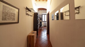 A narrow hallway with tiled flooring, wooden cabinets, and wall-mounted mirrors. - Independent 50 meters from the central and very Tuscan Duomo (Firenze)