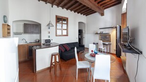A compact kitchen with a dining area, featuring a wooden ceiling, white walls, and a tiled floor. - Independent 50 meters from the central and very Tuscan Duomo (Firenze)