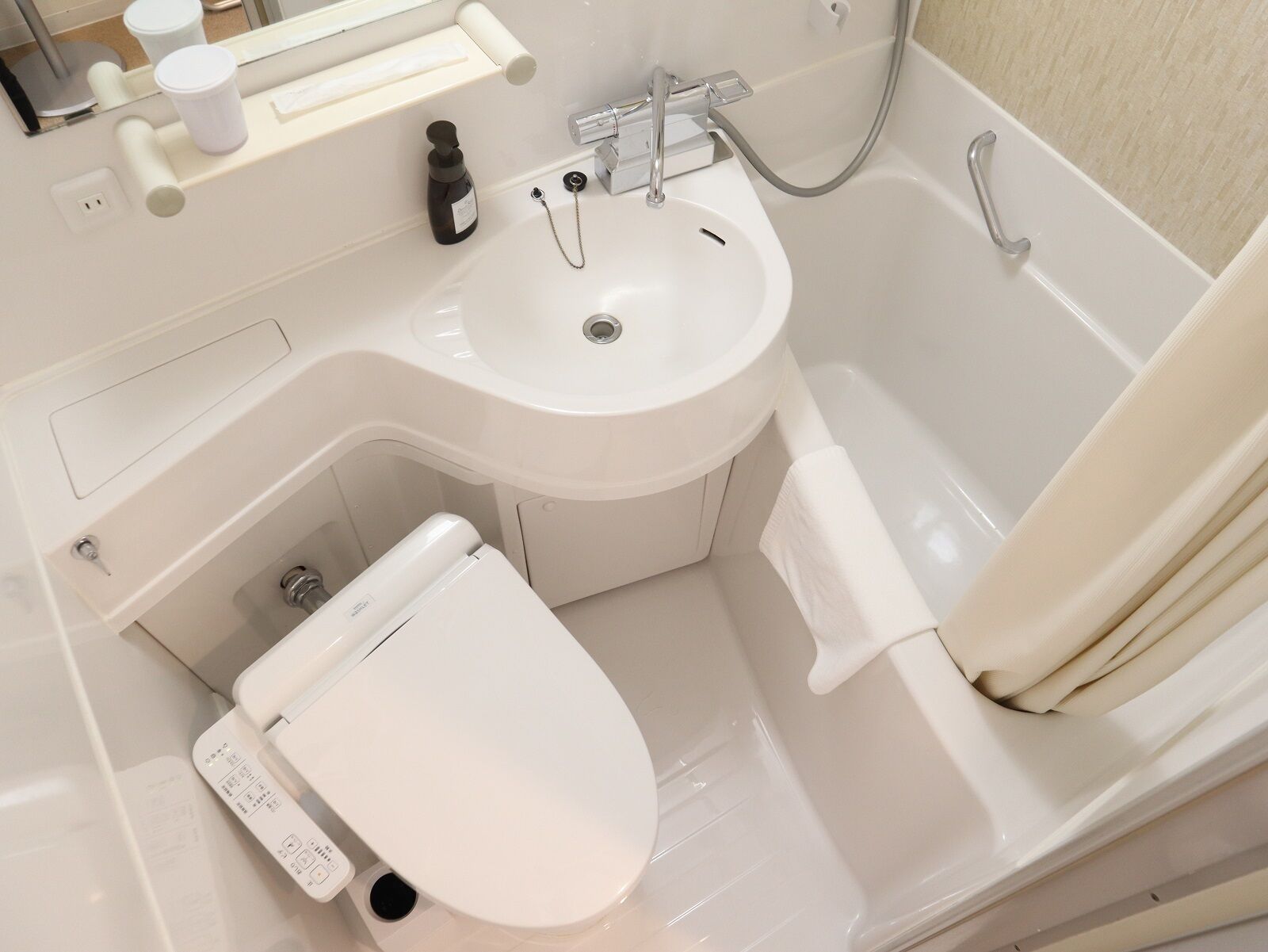 Un baño moderno con lavamanos, inodoro y bañera blancos.