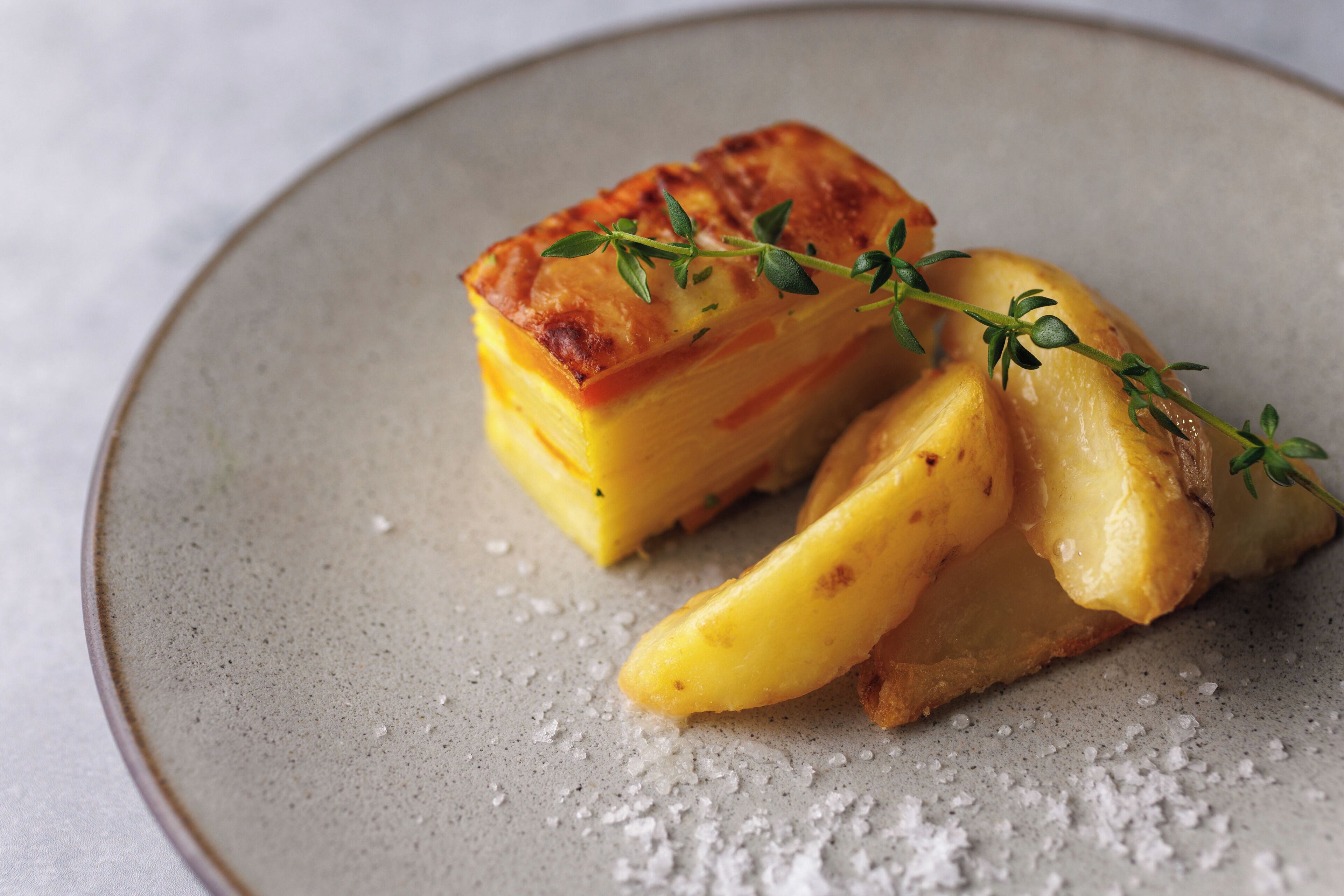 A dessert on a plate with a sprig of thyme.