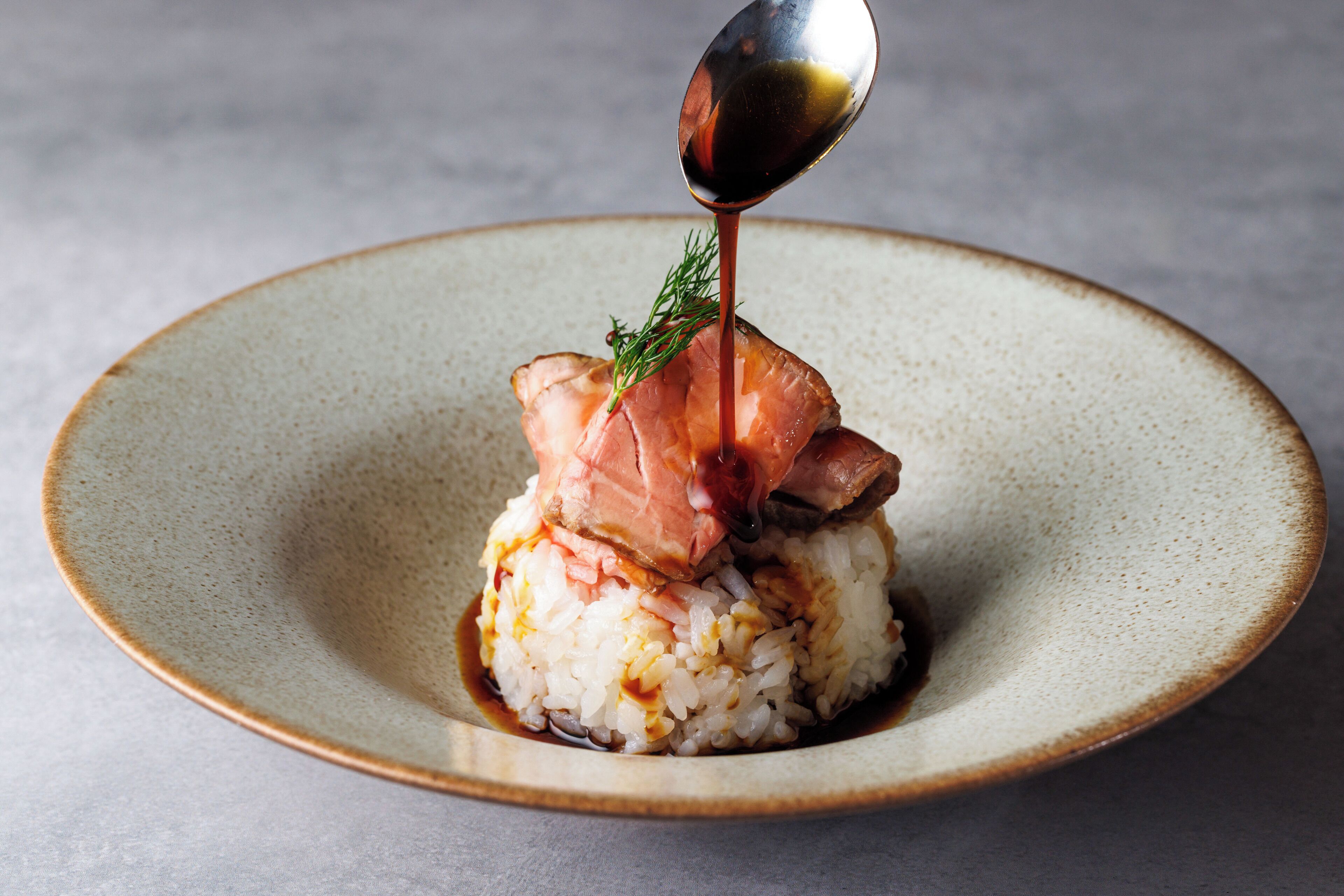 Un plato de sushi con una cucharada de salsa vertida encima.