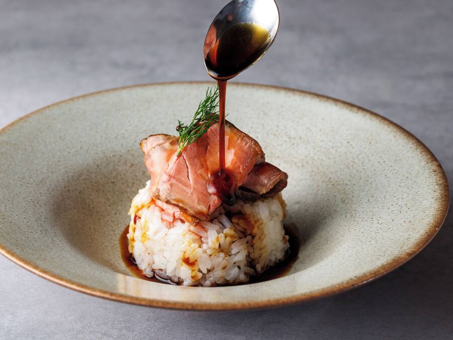 Un plato de sushi con una cucharada de salsa vertida encima.