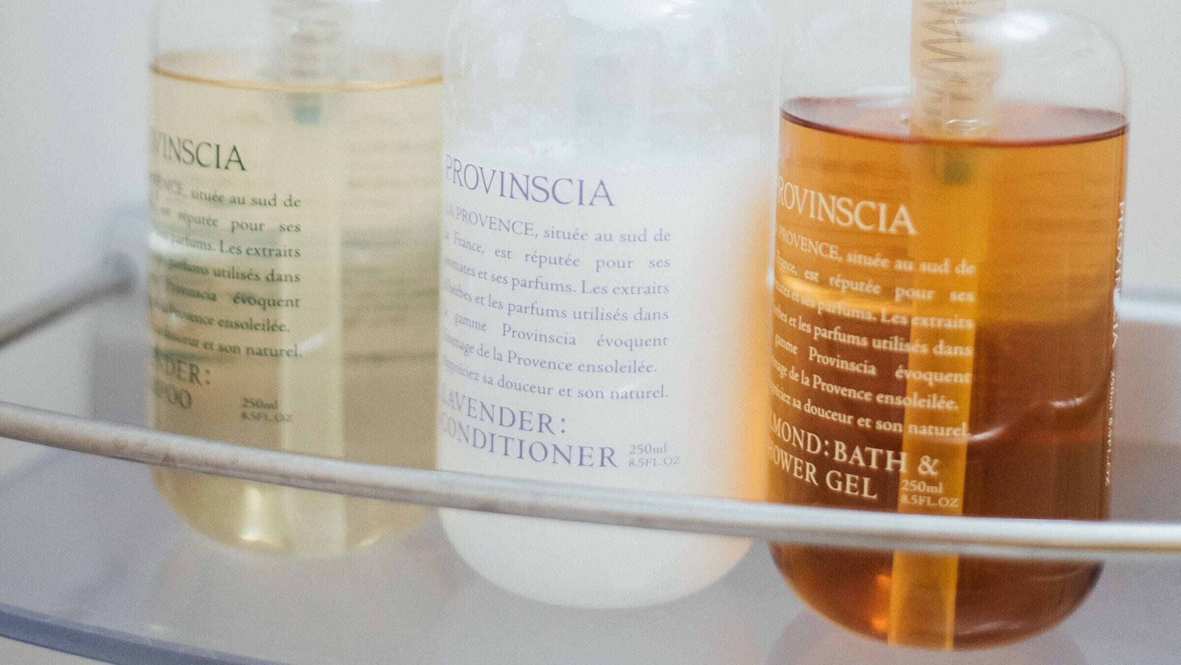 Tres botellas de productos Provincía sobre una estante.