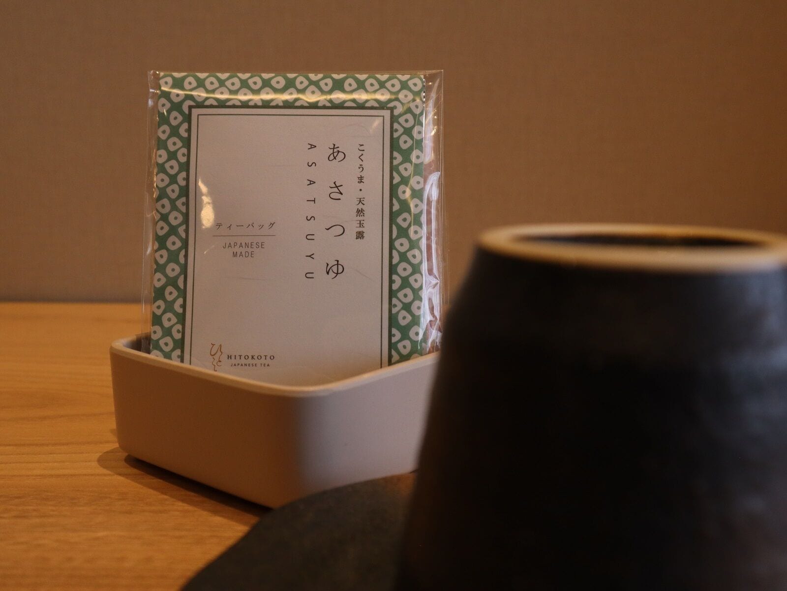 A Japanese tea set with a teapot and a cup, placed on a wooden table.