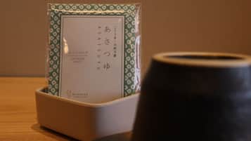 A Japanese tea set with a teapot and a cup, placed on a wooden table.
