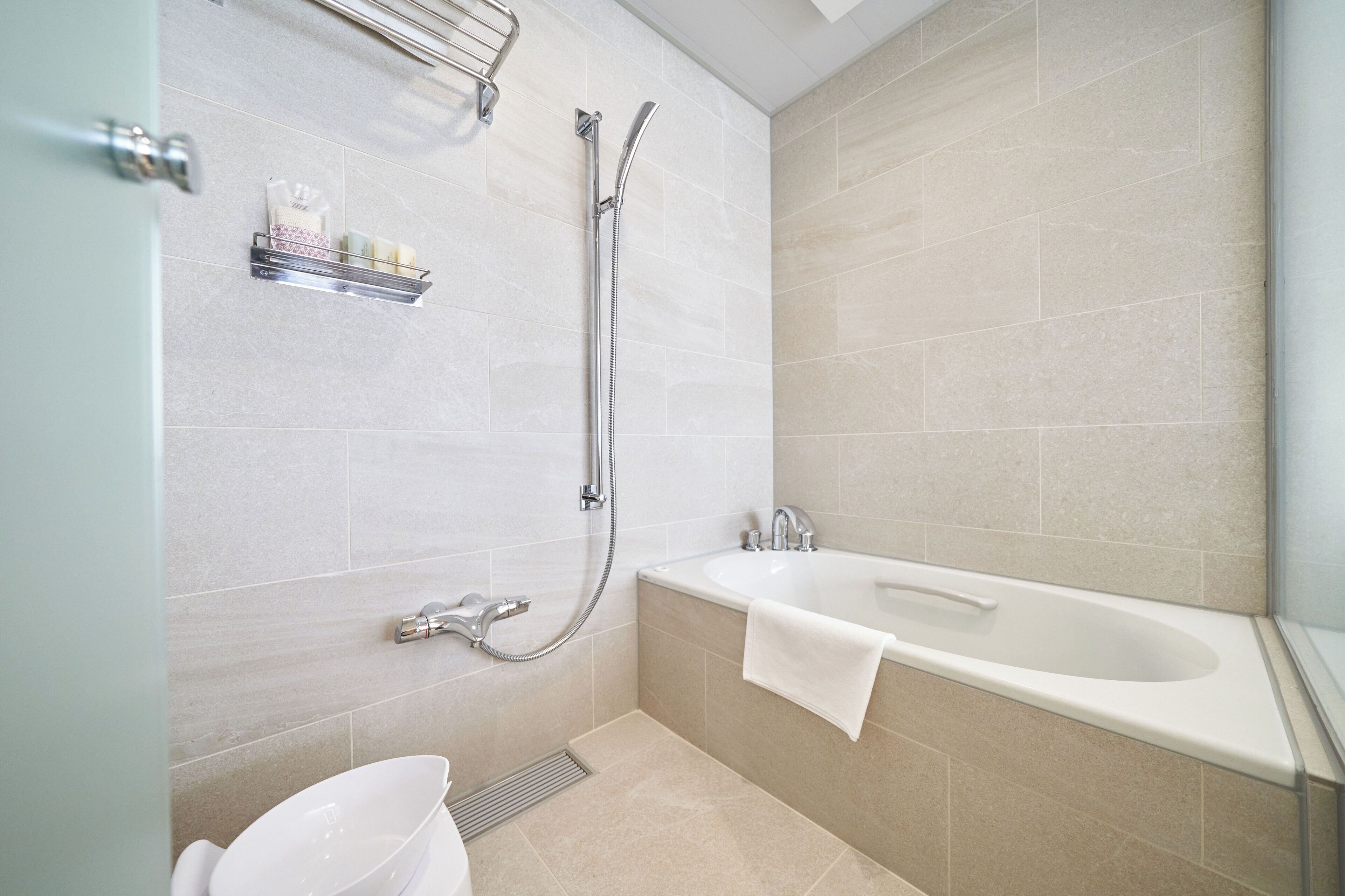 Une salle de bain moderne équipée d’une baignoire, d’une douche et de toilettes.