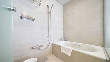 Une salle de bain moderne équipée d’une baignoire, d’une douche et de toilettes.