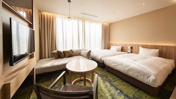 A hotel room with two beds, a sofa, a TV, and a small table.