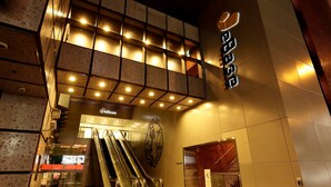 A modern building with a prominent eBase sign, a reception area, and an escalator leading to the entrance. - WeBase TAKAMATSU - Hostel (Takamatsu)
