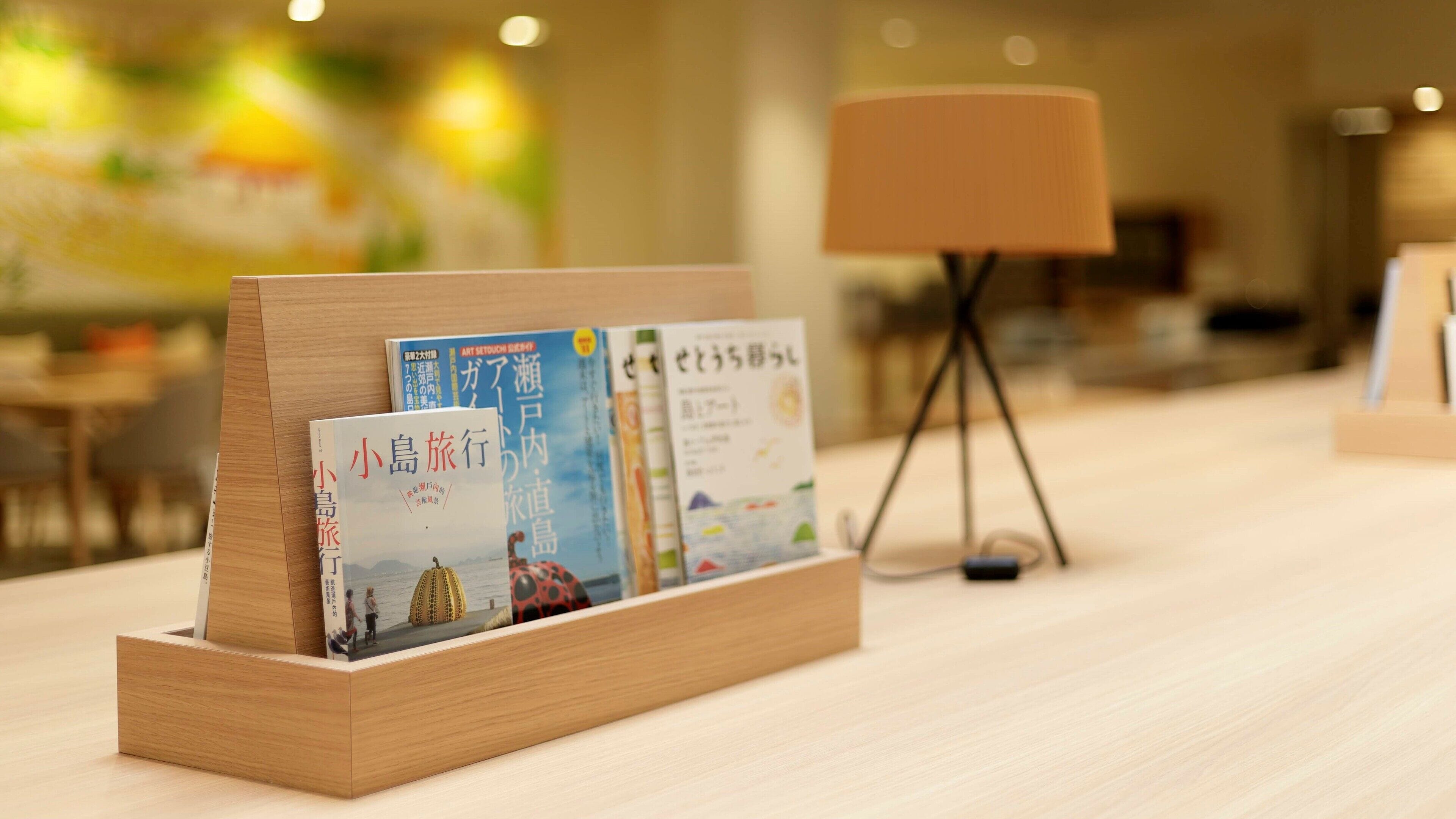 A wooden display stand with books in a hotel lobby.