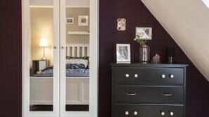 Un dormitorio con cama, cómoda y mesita de noche.