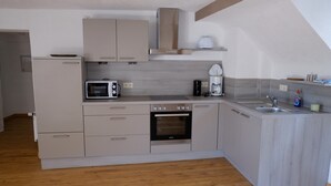A modern kitchen with a built-in oven, microwave, and coffee maker.