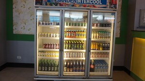 A refrigerated display case labeled "SANDENINTERCOOL" with various beverages. - PP Hotel Dannok (Sadao)