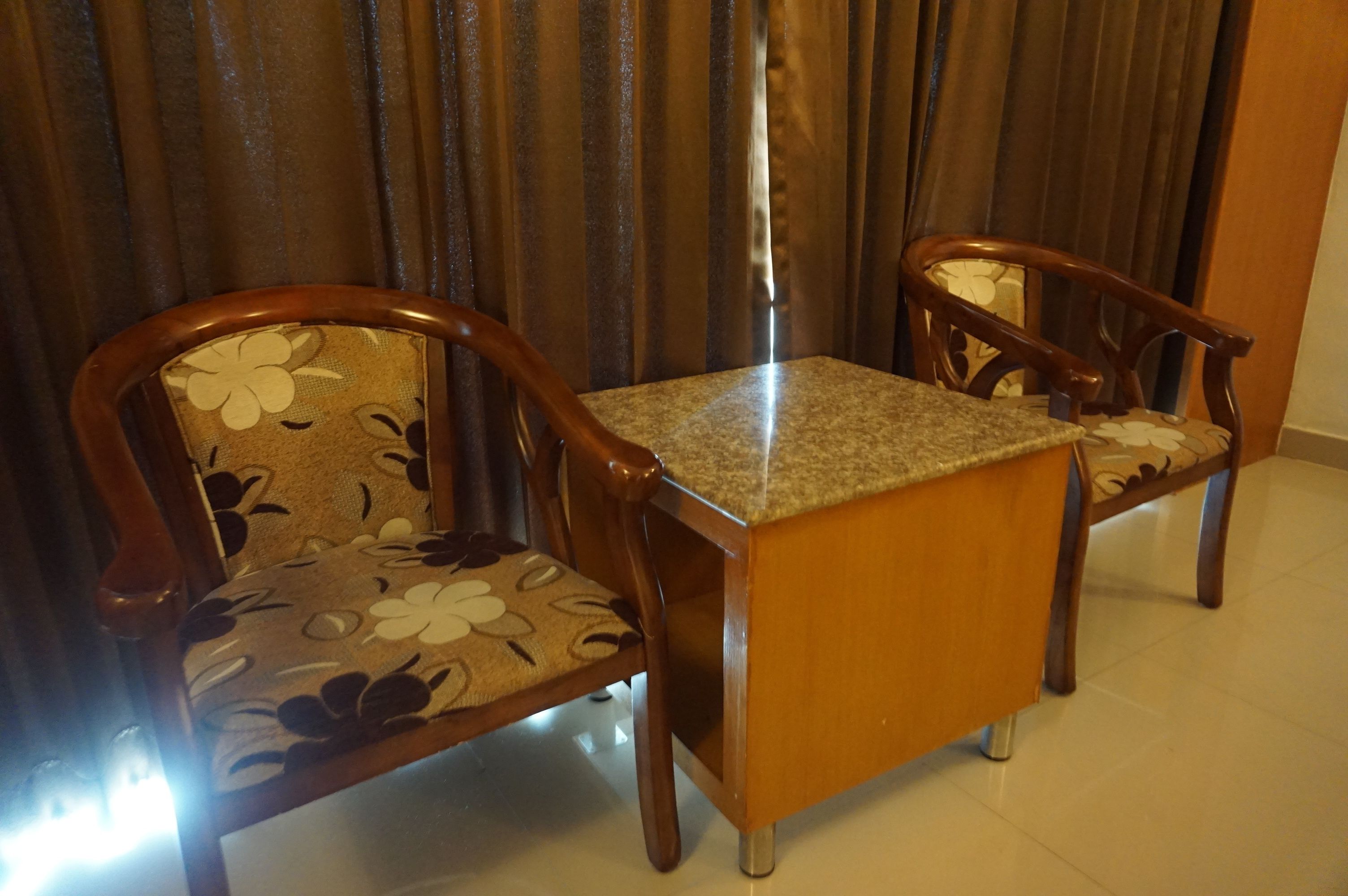 A dining area with two wooden chairs and a small table.