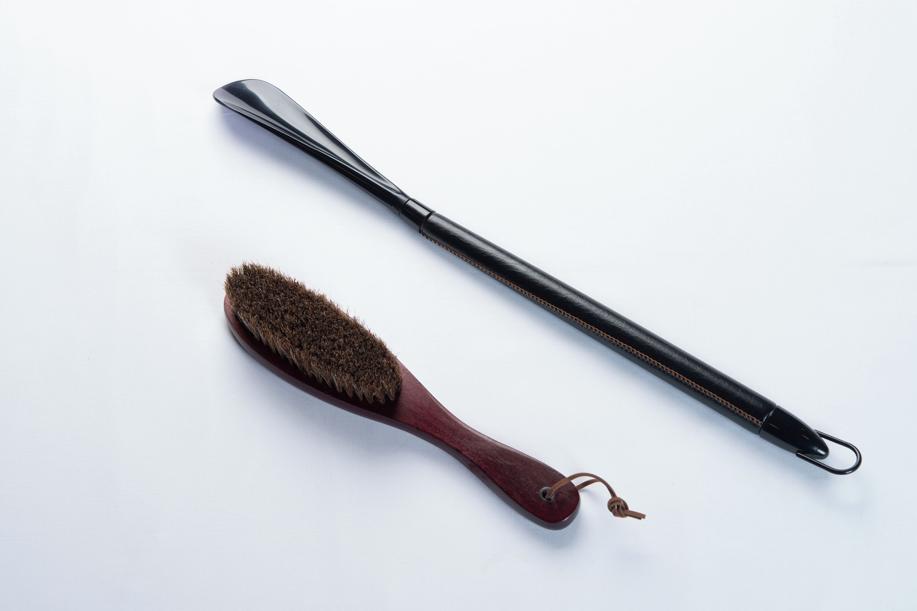 A brush and a long-handled tool on a white background.