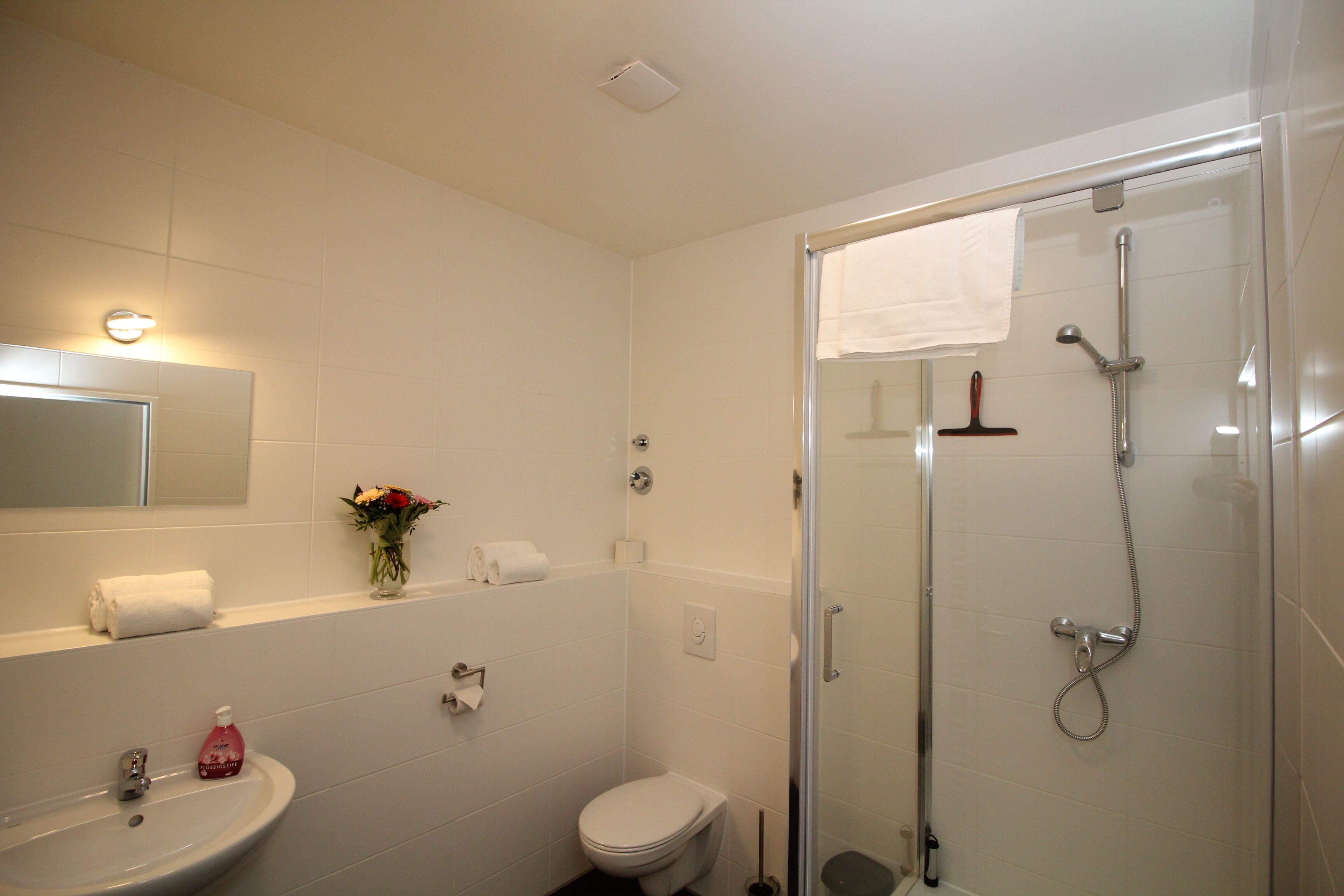 A bathroom with a sink, toilet, and shower.