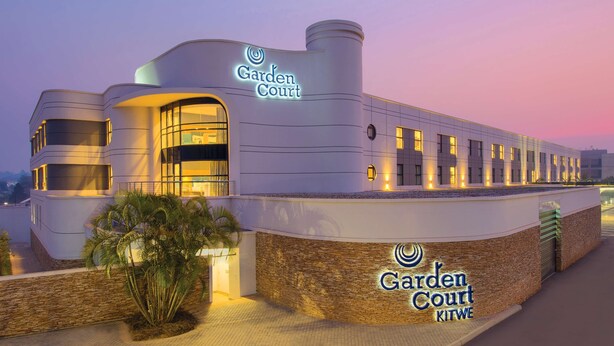 A modern building with a sign reading "Garden Court Kitwe."