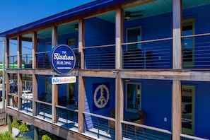 A two-story building with a blue exterior, wooden balconies, and a sign reading "The Hudson Building 106 East Hudson."