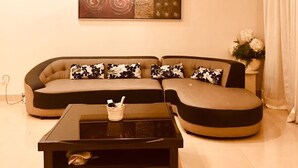 Una sala de estar moderna con un sofá modular, una mesa de centro y una lámpara colgante.
