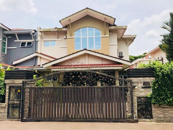 A two-story house with a gated entrance, a large arched window, and a tiled roof. - Botanic Elegant Suite Klang (Pelabuhan Klang)