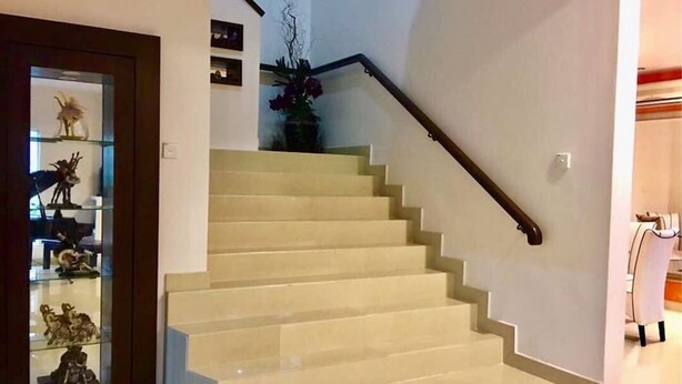 Una escalera con barandilla que lleva a un rellano.