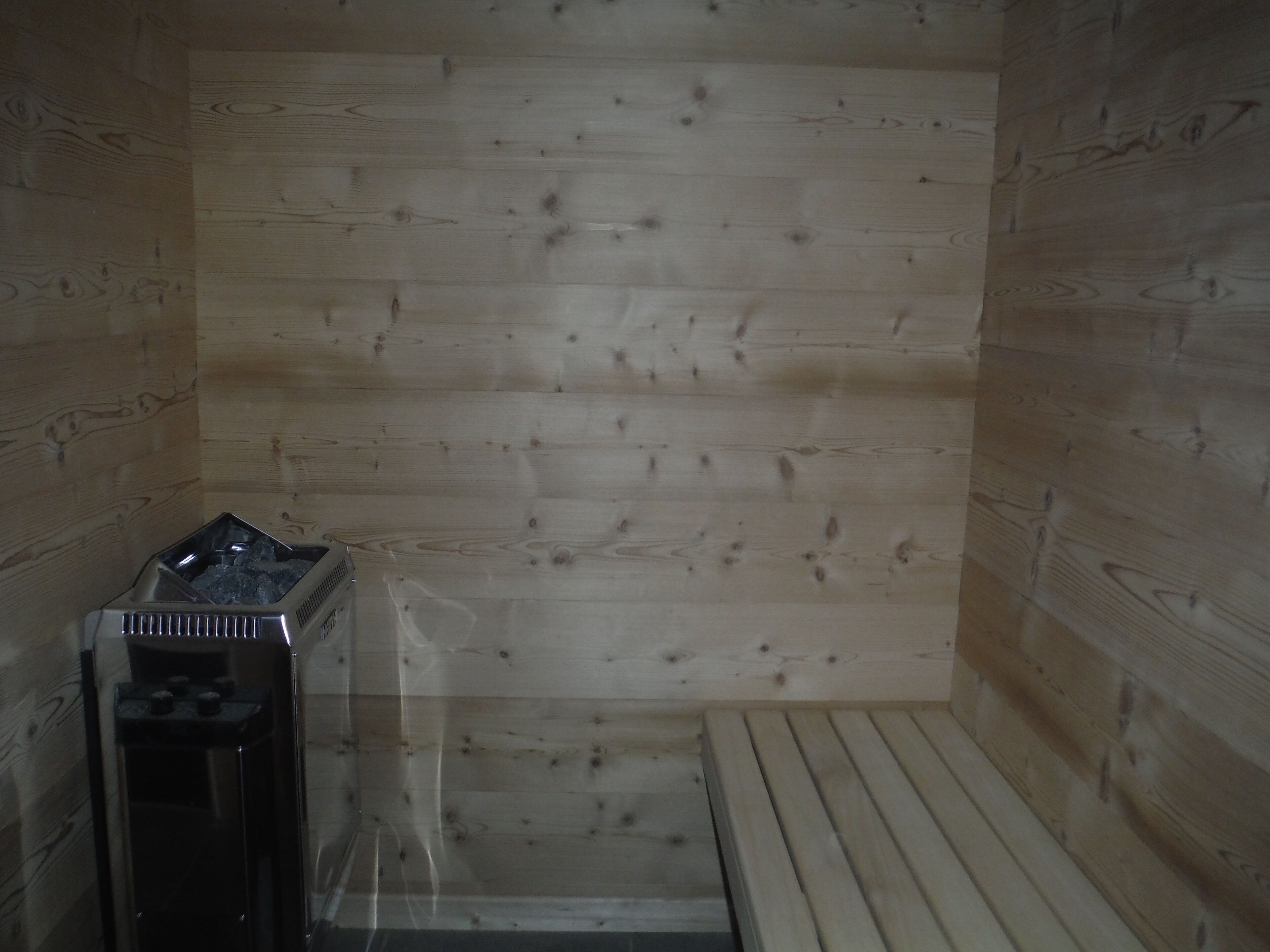 Una sauna con paredes de madera y un banco.