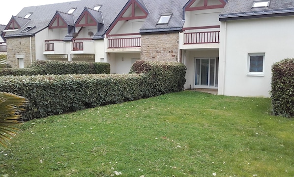 A row of houses with a well-maintained lawn and hedges.